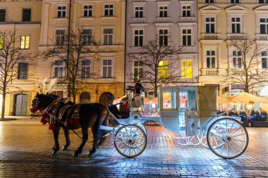 Krakow, Polonya - 22 Ocak 2017: Atlı arabası Main Market Square Krakow, gece görüş, Polonya tarihinde Sukiennice önce
