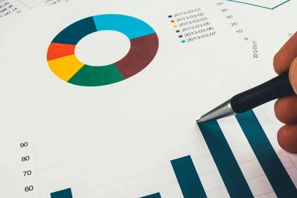 Uomo d'affari che mostra un diagramma su un rapporto finanziario utilizzando una penna — Foto Stock