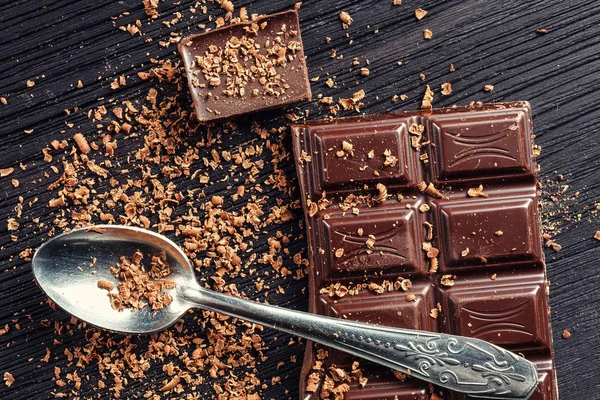 Primer plano de chocolate negro y cuchara sobre fondo de madera oscura — Foto de Stock