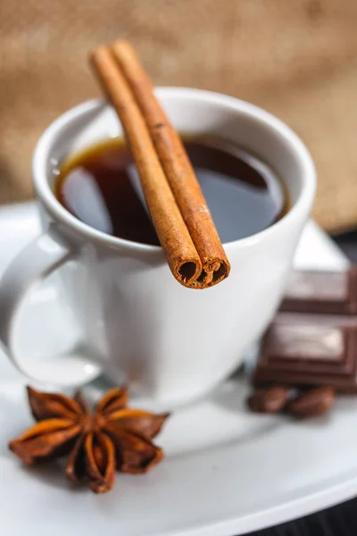 Kopje koffie met anijs, chocolade en kaneel op een houten tafel — Stockfoto