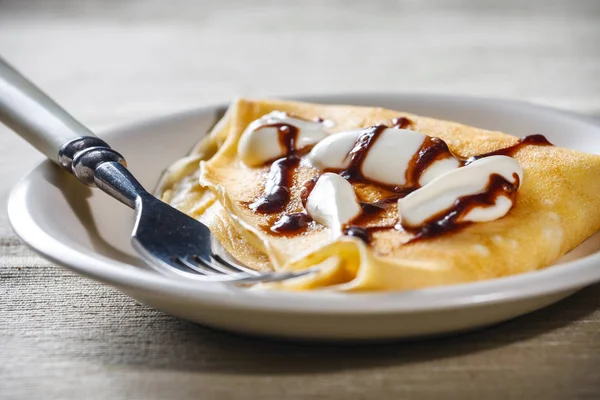 Crepe with whipped cream and chocolate sauce — Stock Photo, Image