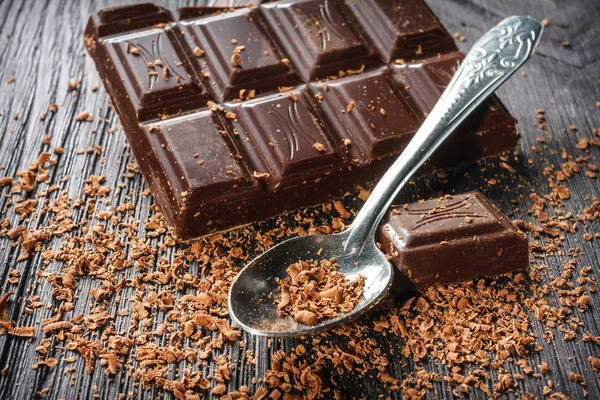Close up of dark chocolate and spoon on dark wooden background — Stock Photo, Image