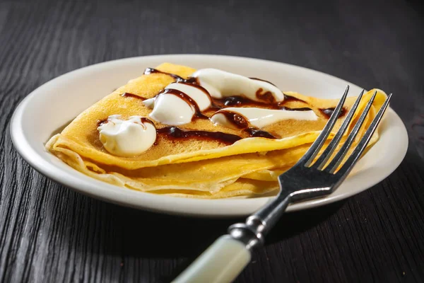 Crepe with whipped cream and chocolate sauce — Stock Photo, Image