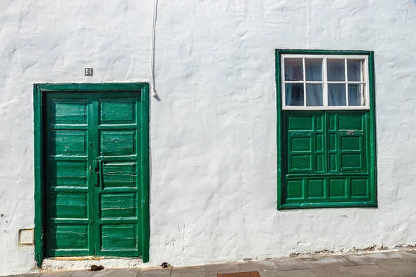 Zielone drzwi i okna na tle białej ściany — Zdjęcie stockowe