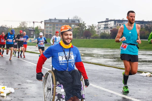 KRAKOW, POLONIA - 30 de abril de 2017: Hombre discapacitado no identificado en maratón en silla de ruedas en las calles de la ciudad durante la maratón de Cracovia 16. La maratón es un evento anual . —  Fotos de Stock