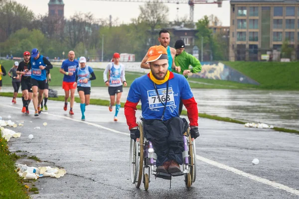 Krakau, Polen - 30. April 2017: Unbekannter behinderter Mann im Marathon auf einem Rollstuhl auf den Straßen der Stadt während des 16. Krakauer Marathons. Der Marathon ist ein jährliches Ereignis. — Stockfoto