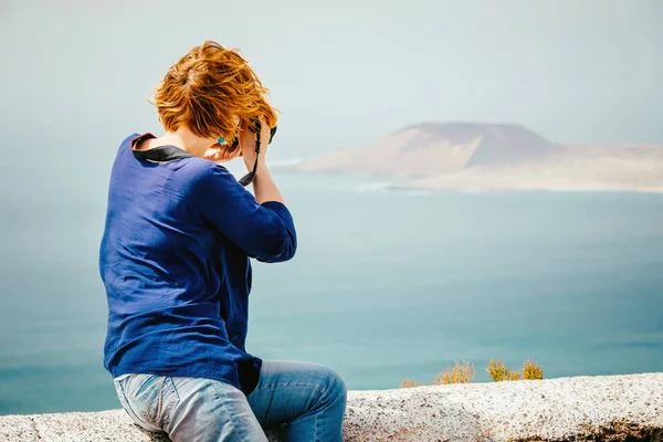 Vrouwelijke reiziger nemen van een foto aan de kust — Stockfoto