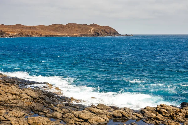 Vulkaniska kust med vågiga havet och blå himmel, Lanzarote island, Spanien — Stockfoto