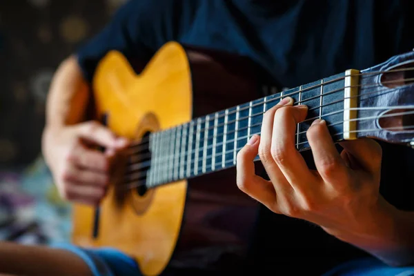 Νεαρός μουσικός παίζοντας ακουστική κιθάρα, ζωντανή μουσική στο παρασκήνιο — Φωτογραφία Αρχείου