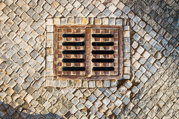 Закрытие канализационного люка на тротуаре — стоковое фото