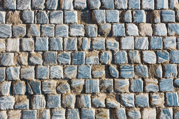 Grijze stenen weg textuur op zonnige dag — Stockfoto