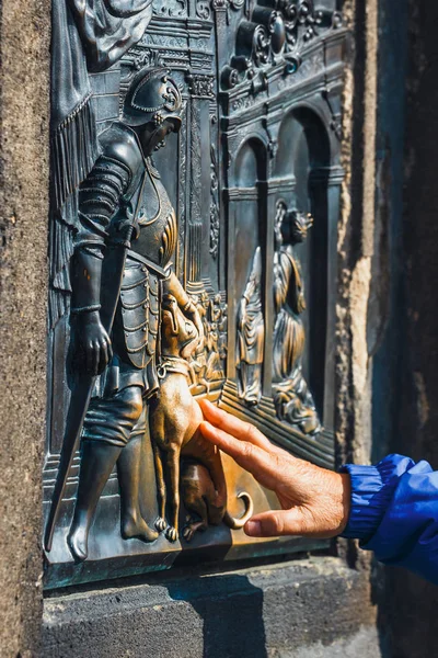 Le bas-relief sur le pont Charles à Prague, touchant la sculpture du chien pour la chance et la fidélité — Photo