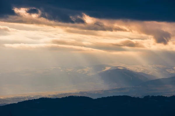 Raggi di luce attraversano le nuvole, paesaggio montano — Foto Stock