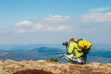 kadını uçurum üzerinde oturur ve bir fotoğraf çeker