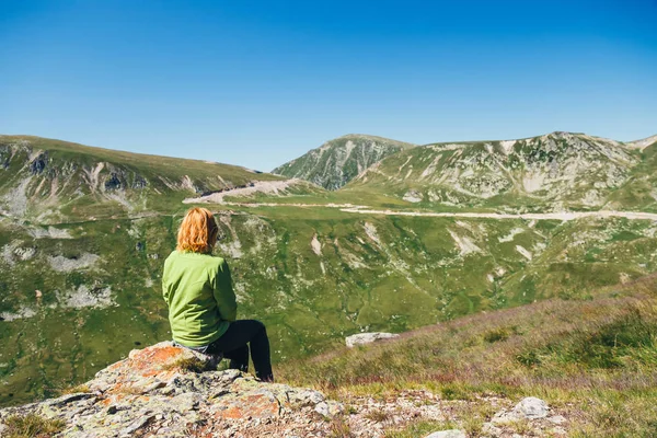Vrouw zit op de top en bewondert het prachtige uitzicht op Parang bergen, Roemenië — Stockfoto