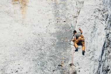 Polonya, Podlesice - 04 Şubat 2017: Yan görünüm yetişkin erkek kaya tırmanışçısı zavallı kabartmalı dikey düz duvarda. Gora Zborow dağcılar arasında çok popüler bir yer 