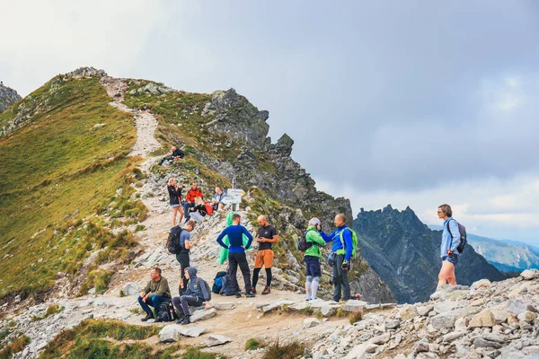 Tatra gebergte, Polen, 14 augustus 2017: Unidentified groep wandelaars rusten en uitgeput bij Krzyzne Pass in de Hoge Tatra bergen, Polen — Stockfoto
