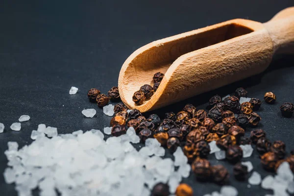 Black pepper and salt on rustic stone background. Overhead view food photography — Stock Photo, Image