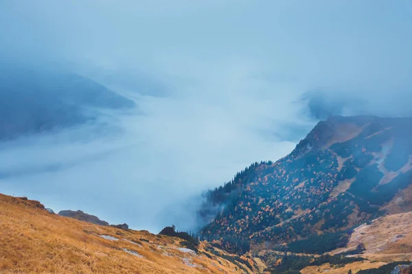 Neblige Berglandschaft mit Wolken über den Gipfeln — Stockfoto