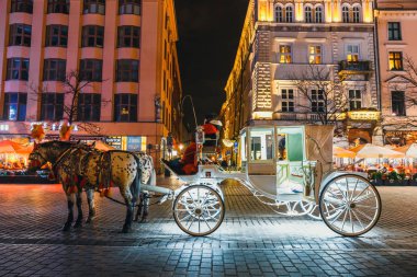 Krakow, Polonya - 15 Aralık 2017: Atlı arabası Main Market Square Krakow, gece görüş, Polonya tarihinde Sukiennice önce