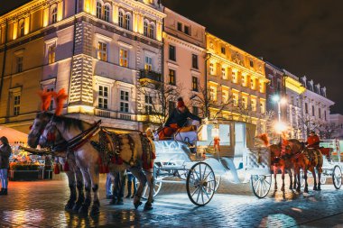 Krakow, Polonya - 15 Aralık 2017: Atlı arabası Main Market Square Krakow, gece görüş, Polonya tarihinde Sukiennice önce