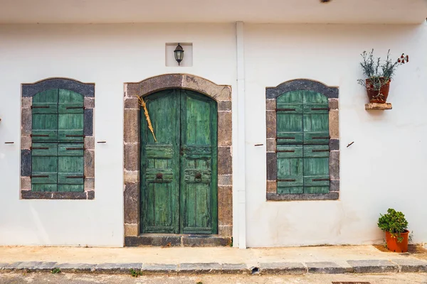 Zielone okiennice i drzwi na białej ścianie, bliska — Zdjęcie stockowe