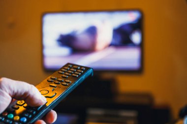 TV uzaktan kumanda tutan el ve presler düğmesine