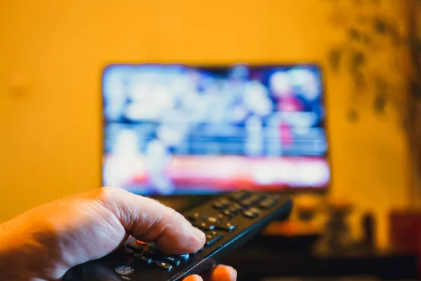 Hand houden van de afstandsbediening van de Tv en op de knop drukt — Stockfoto