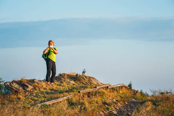 Γυναίκα στέκεται στην κορυφή και θαυμάζει την όμορφη ανατολή του ηλίου — Φωτογραφία Αρχείου