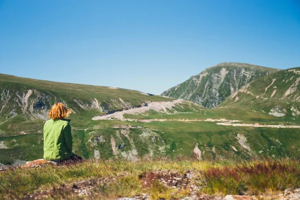 妇女坐在顶端和欣赏美丽的景色宝蓝山脉, 罗马尼亚 — 图库照片