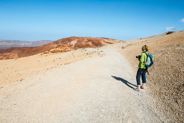 Een jonge vrouw is wandelen in de bergen en prachtig uitzicht bewondert — Stockfoto