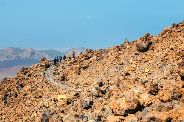 Tenerife, España, 07 de junio de 2015: personas desconocidas caminan a lo largo del sendero de montaña en la cima del volcán el teide, España — Foto de Stock