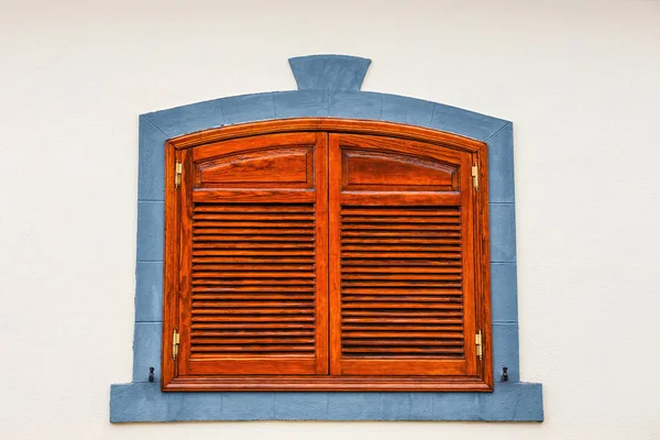 brown shutters on a white wall, close up