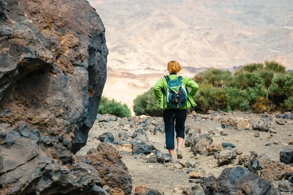 Uma jovem mulher está andando nas montanhas e admira belas vistas — Fotografia de Stock