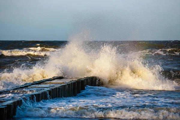 Otoño tormenta de mar con salpicaduras de grandes olas sobre el muelle de la costa báltica —  Fotos de Stock