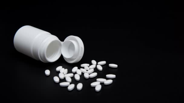白色药丸和白色瓶子在黑色背景 — 图库视频影像