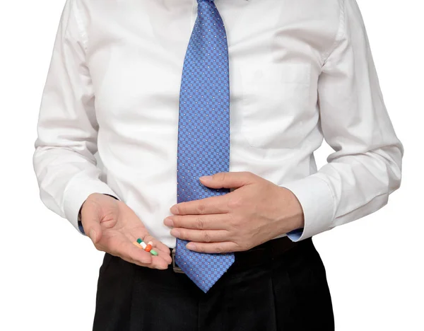 Empresario sosteniendo píldora en la mano y sosteniendo dolor abdominal . — Foto de Stock