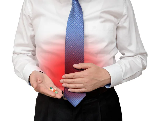 Empresario sosteniendo píldora en la mano y sosteniendo dolor abdominal . — Foto de Stock