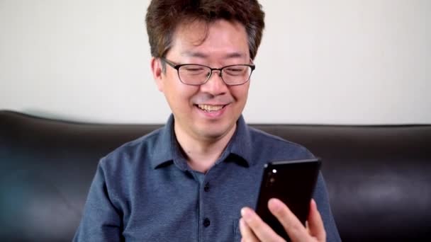 Asiático Mediana Edad Hombre Teniendo Una Videollamada Feliz Usando Teléfono — Vídeos de Stock