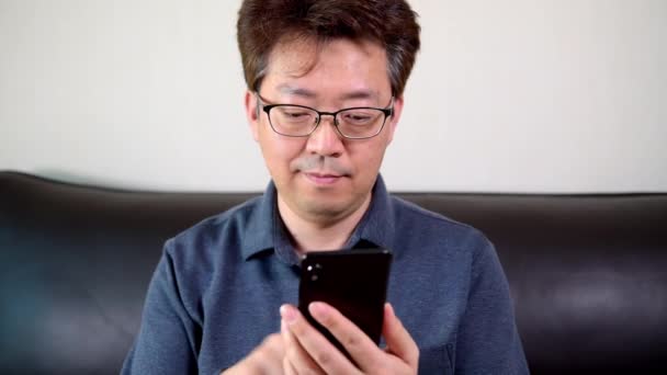 Asiático Mediana Edad Macho Tratando Leer Algo Teléfono Móvil — Vídeos de Stock
