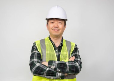 Açık yeşil iş yeleği ve beyaz şapkalı Asyalı orta yaşlı bir adam..