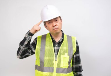 Orta yaşlı bir Asyalı işçi, bir şey hakkında dikkatlice düşünüyor..