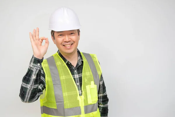 中年のアジア人労働者が手を挙げてサインをする. — ストック写真