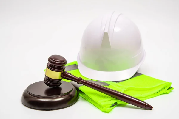 Μια εργασιακή νομική έννοια με καπέλα ασφαλείας, ρούχα εργασίας, και ένα δικαστή Gavel σε λευκό φόντο. — Φωτογραφία Αρχείου