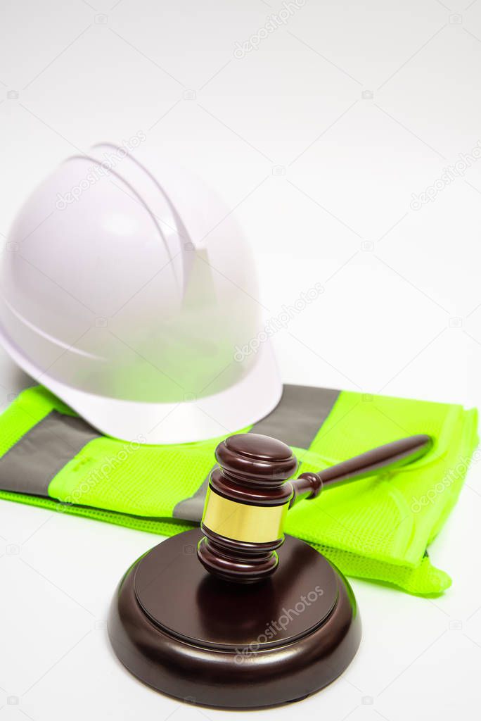 A labor-related legal concept with safety hats, work clothes, and a judge gavel on a white background.