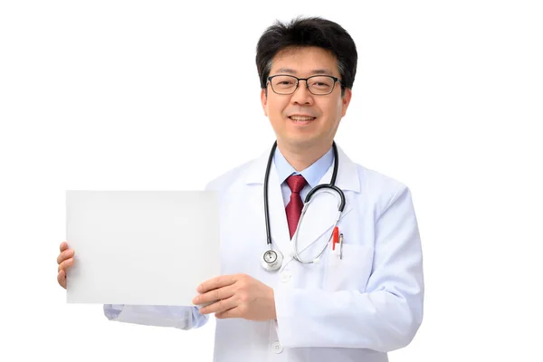 Médico asiático de meia-idade segurando placa de mensagem no fundo branco — Fotografia de Stock