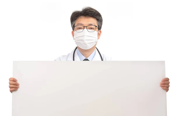 Um médico asiático segurando um quadro de mensagens em branco . — Fotografia de Stock