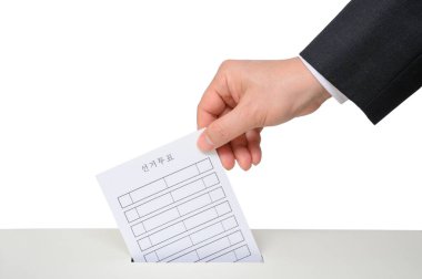 Oy sandığındaki oy pusulasını erkekler veriyor..