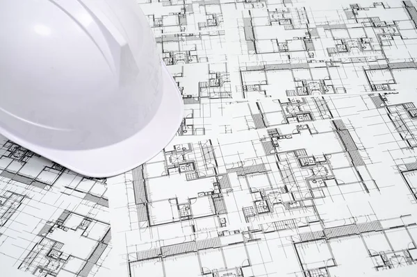 Concepto de la industria de la construcción con un sombrero duro en el dibujo arquitectónico — Foto de Stock