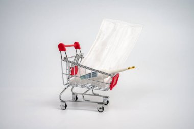 Alışveriş arabasında tıbbi maske ve termometre var.